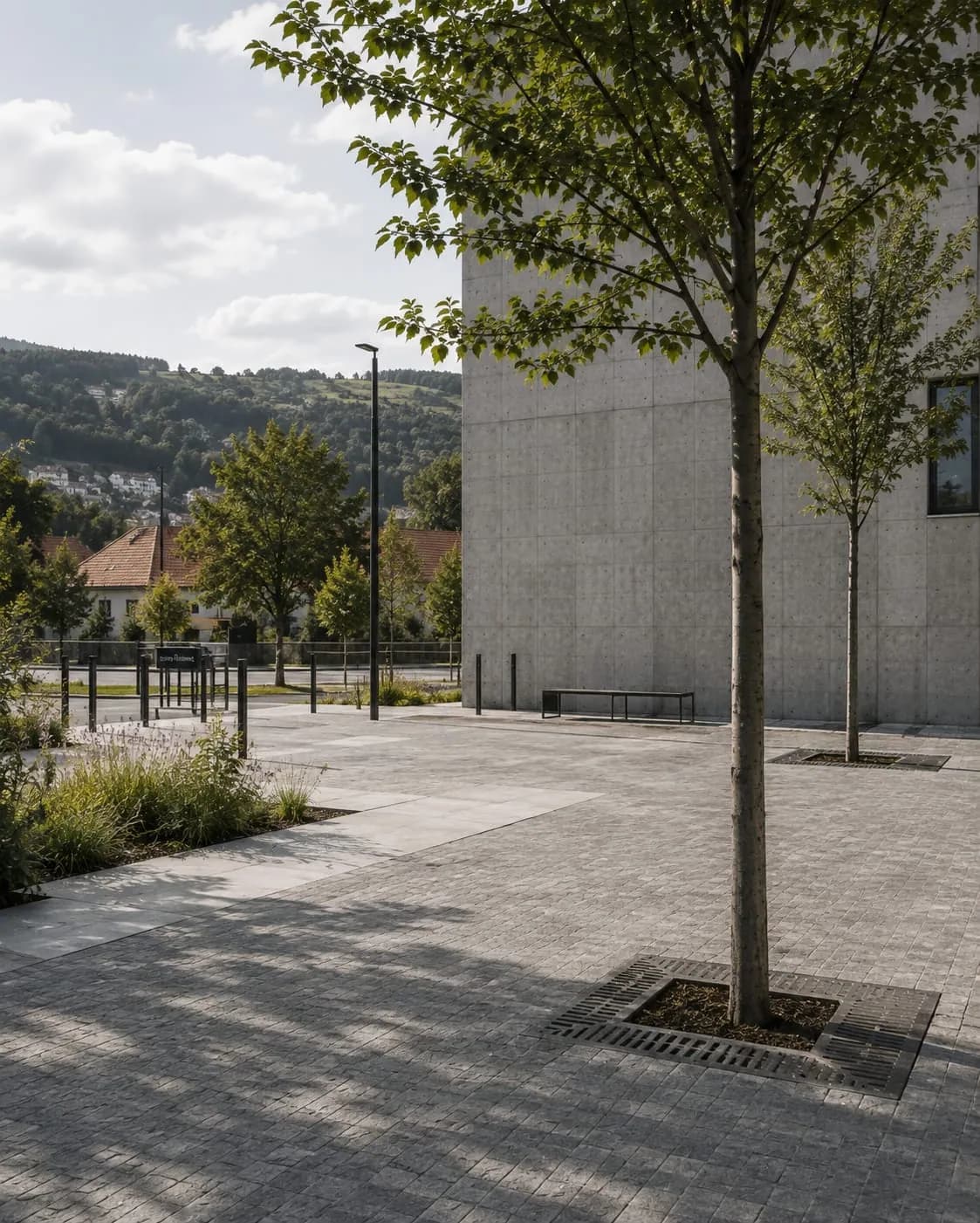 Veřejný prostor s betonovou budovou a stromy